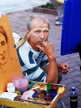 artist draws  person portrait  on paper sheet