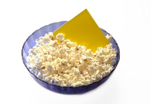 Popcorn in a blue basket. In the popcorn inserted yellow sign. Isolated on a white background.