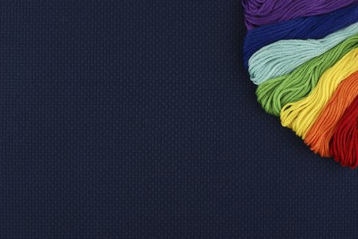 Multi-coloured threads on a dark blue background
