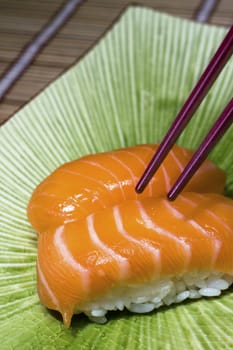 Fresh sushi and chopsticks on disk onbamboo mat 