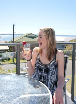 young woman with glass of champagne in outdoors cafe or restaurant