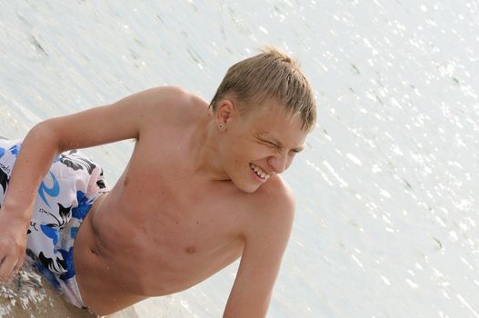 The young man bathes in the sea