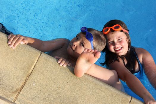 brother and sister with diving glasses in the swimmingpool