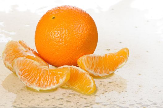 The whole orange with segments lays in juice