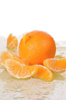 The whole orange with segments lays in juice