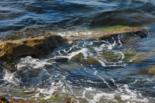 The stone in water is washed by waves