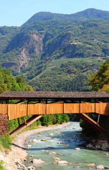 The Wooden Bridge Over the Adige River at the Foot of the Italian Alps