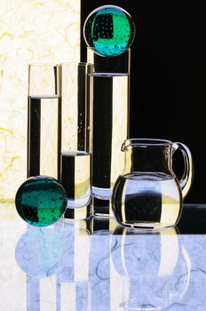 Glass glasses and jug on a multi-coloured background