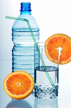 Water in a plastic bottle and a glass isolated on white background