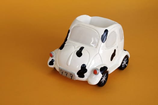 Toy ceramic car in isolated over yellow