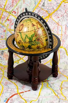 an old globe standing on a map - close up