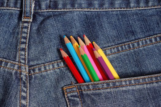 some crayons on a jeans background