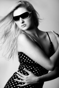 Beautiful girl with a pair off sunglasses in the studio