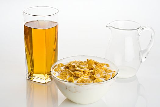 Big glass of apple juice and  corn-flakes with milk