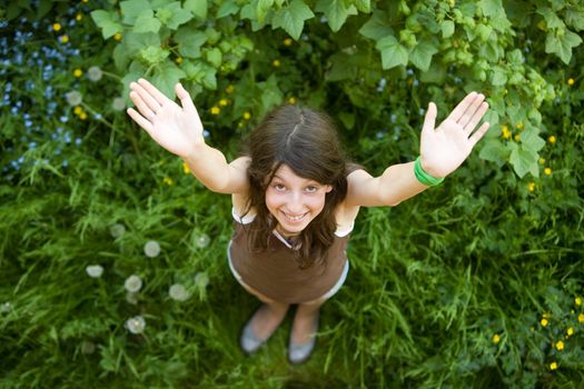 The girl with a happy smile on a green grass 
