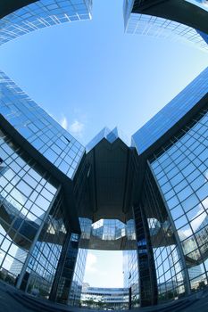 Complex of office buildings with mirror walls in which the sky is reflected
