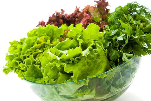 Some bunches of fresh salads in a glass bowl 
