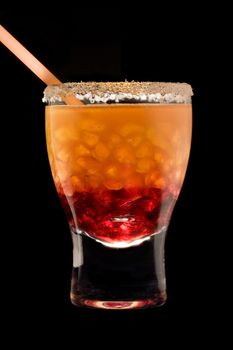 Cocktail in a glass with a tubule on a black background
