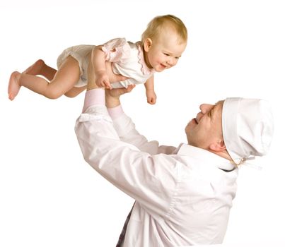 The doctor in a white dressing gown holds on hands the small smiling girl in a dress on a white background
