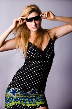 Beautiful girl with a pair off sunglasses in the studio