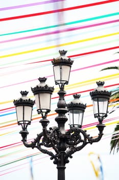 Old street lamp with colorful ribbon in background