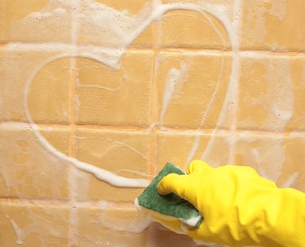 hand in yellow rubber glove draws heart