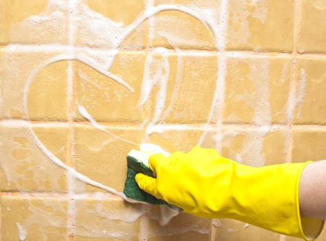 hand in yellow rubber glove draws heart