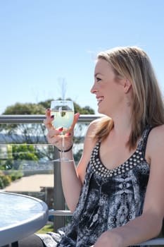 young woman with glass of wine in outdoors cafe or restaurant