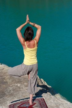 Early morning yoga excecises on the shore of a lake