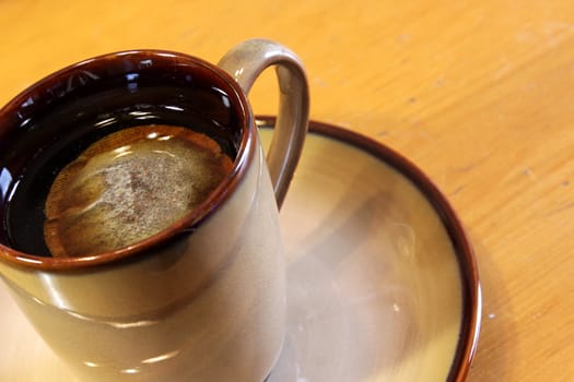 A bag of tea sitting a mug of hot water.
