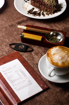 check, ashtray, cigar, lighter and coffee at restaurant table