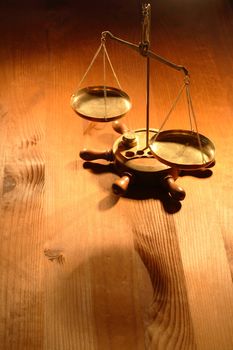 Ancient brass weight scale standing on nice wooden background