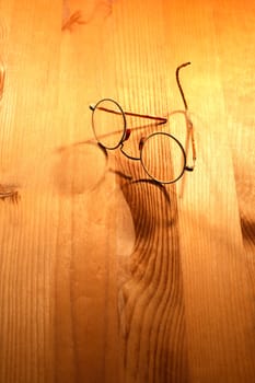 Vintage spectacles lying on nice yellow wooden background