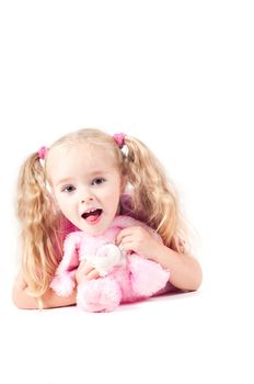 Little cute girl in pink and with ponytails in studio