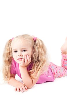 Little cute girl in pink and with ponytails in studio