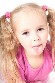 Little cute girl in pink and with ponytails in studio