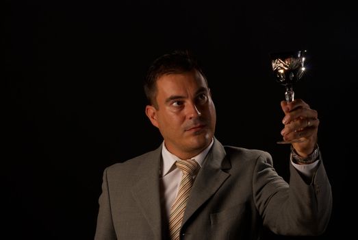 Man holding up a crystal glass with white wine