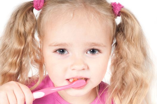 Little cute girl in pink and with ponytails in studio