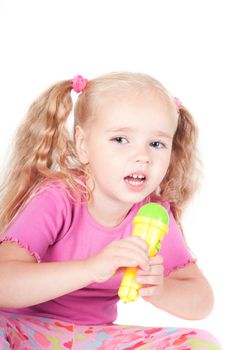 Little cute girl in pink and with ponytails in studio