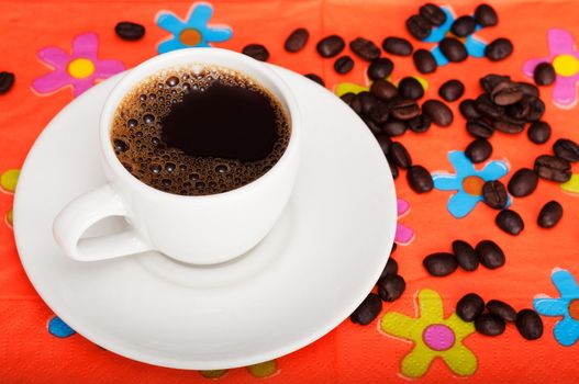 Fresh cup of coffee on a bright colorful background with coffee beans