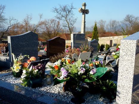 Lots of beautiful flowers covering a tomb in a cemetery