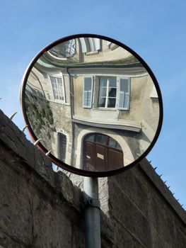 Mirror reflecting an od building facade in a street