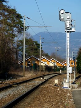 Railway next to red houses in the countryside