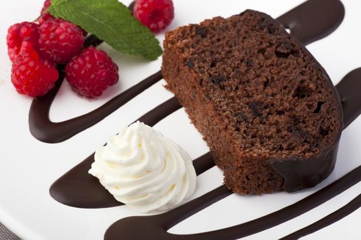 Fresh chocolate cake with raspberries and whipped cream.