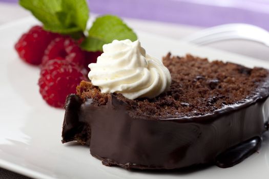 Fresh chocolate cake with raspberries and whipped cream.