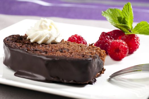 Fresh chocolate cake with raspberries and whipped cream.