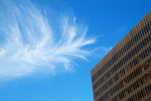 Brown office building with blue sky cloudscape