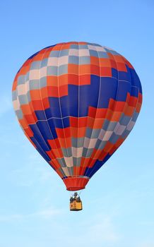 Vivid hot air balloon floating in the blue sky.