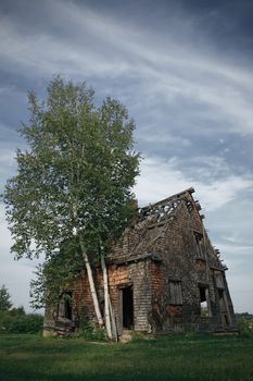 Spooky abandoned rural house in the field.