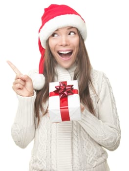 Christmas woman showing copy space pointing up to the side being excited and surprised. Isolated on white background. Joyful young smiling woman in Santa hat and sweater showing empty copyspace. Asian / Caucasian female model.